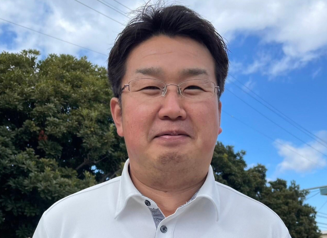 空をバックにオーナーがにっこり微笑んでいる正面写真